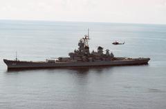 Battleship USS Wisconsin (BB-64) with UH-1N Iroquois helicopter hovering overhead in the Atlantic Ocean