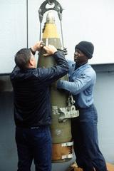 Sailors attaching lifting cables to a 16-inch projectile aboard USS Wisconsin during Operation Desert Shield
