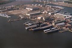 Aerial view of Philadelphia Naval Shipyard with decommissioned ships including battleships Iowa and Wisconsin, aircraft carriers Forrestal and Saratoga, amphibious assault ships Iwo Jima and Guadalcanal, taken on 30 October 1995