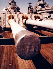 Close-up view of 15-inch/50 caliber gun on USS Wisconsin (BB 64) with USS Iowa (BB 61) visible in background both battleships in mothball fleet