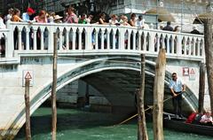Ponte della Paglia bridge over a canal in Venice with historic buildings and gondolas