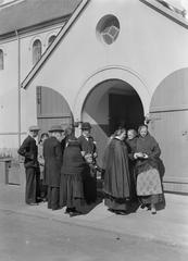 Group of churchgoers including women in traditional Icelandic clothing at the south portal of the cathedral in Reykjavik, Iceland, 1934