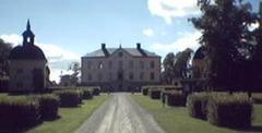 Hasselby Castle surrounded by trees and overlooking a lake