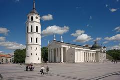 Vilnius Cathedral Square with historic bell tower and castle wall under a bright summer sky