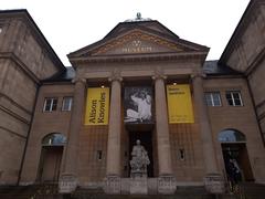 Entrance of Museum Wiesbaden with modern glass facade and visitors