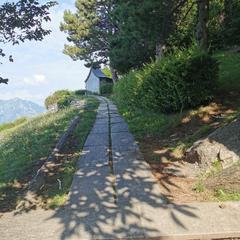 Access path to Madonna del Resegone statue in Lecco with scenic mountainous background