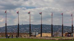 Szent György Square with multiple flagpoles in Budapest under a clear sky in May 2014