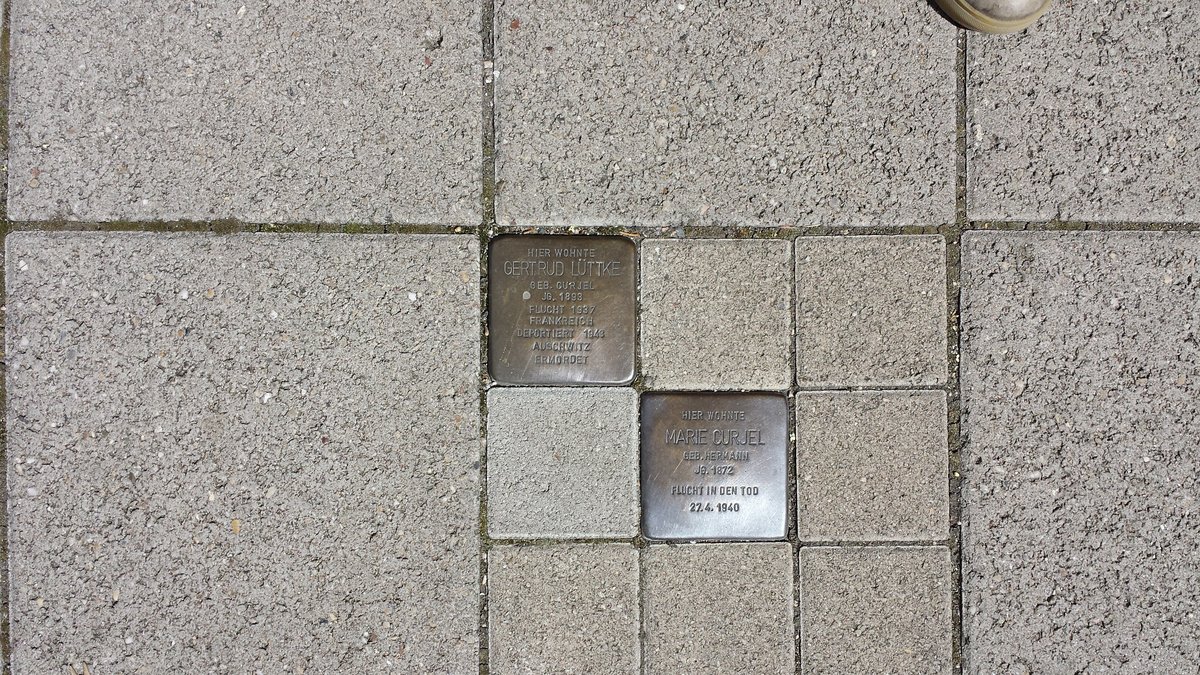 Stolperstein dedicated to Marie Curjel in Karlsruhe, Germany placed on a cobblestone sidewalk