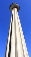 Looking up at the Tower of the Americas with the San Antonio skyline and Riverwalk in view