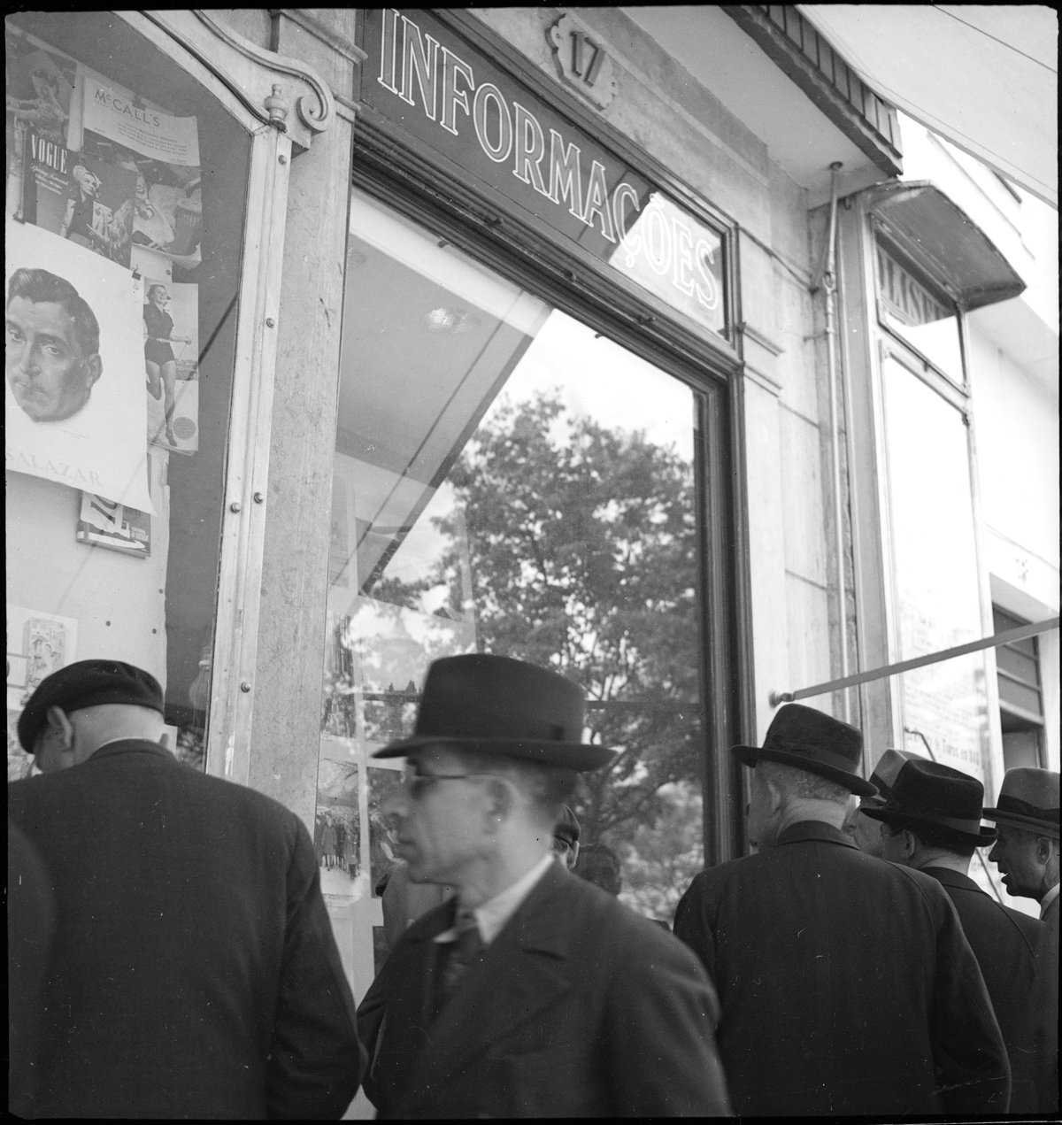Men standing in front of a market hall window in Lisbon, Portugal