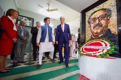 U.S. Secretary of State John Kerry walking past a wreath at a memorial in Dhaka, Bangladesh