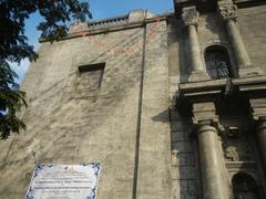 Street view of General Luna Street in Intramuros, Manila with landmarks including San Agustin Church, Manila Cathedral clock tower and dome, Patio Victoria, and Plaza de Roma with King Charles IV monument