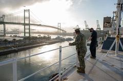 Hospital ship USNS Mercy departing Port of Los Angeles with naval personnel observing