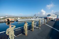 Sailors on USNS Mercy hospital ship rendering honors to the USS Iowa Battleship Museum as the ship departs the Port of Los Angeles