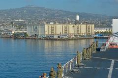 USNS Mercy hospital ship sailing out of Port of Los Angeles with sailors looking out on deck