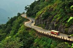 Scenic view of Thamarassery Churam mountain pass in Vythiri Taluk, India with lush green hills and winding road