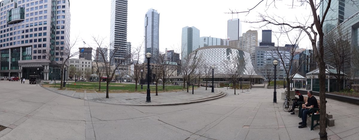 Panoramic view of the park near Roy Thompson Hall in Toronto with lush green trees and pathways