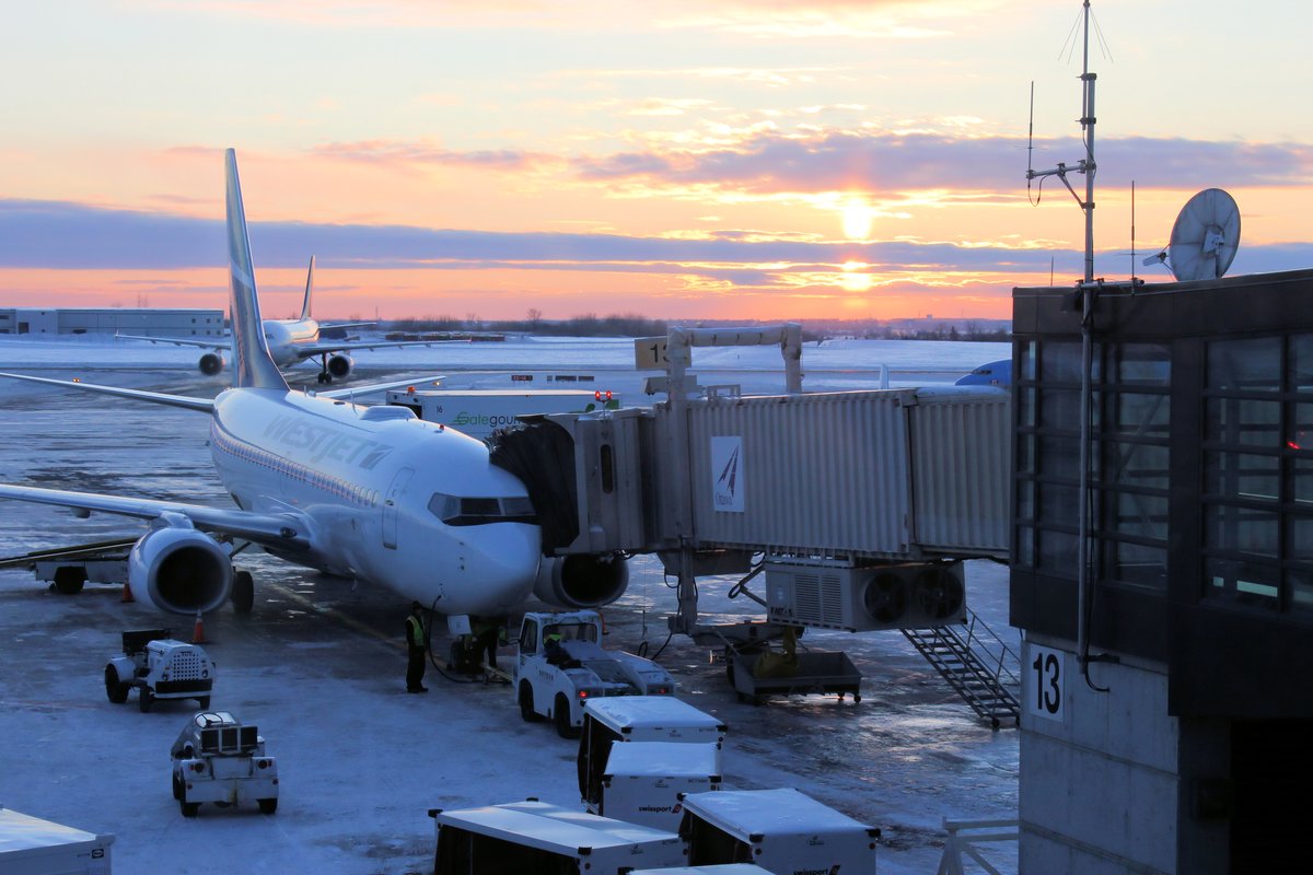 Sunset at Ottawa International Airport with planes and runway under colorful sky