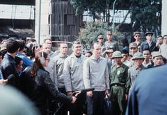 American POWs lined up at Gia Lan Airport surrounded by North Vietnamese military and press before transfer to U.S.