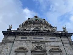 Statues on the roof of Marmorkirken church in Copenhagen under clear blue sky