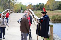Revolutionary War reenactor talking to visitors at Minute Man National Historical Park North Bridge Concord Massachusetts