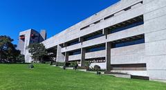 Facade of El Colegio de Mexico building with clear blue sky