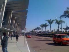 Outside Terminal 2 building at San Diego International Airport with parked taxis and vehicles