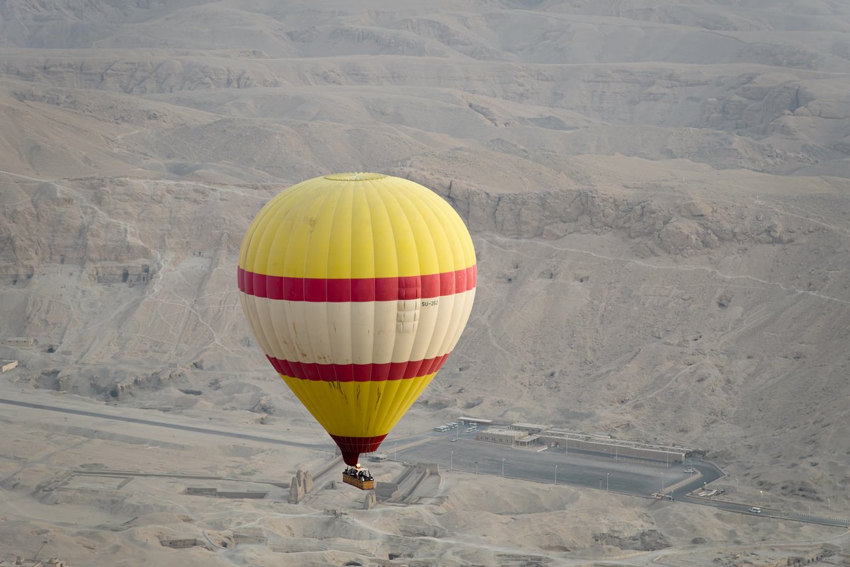 Aerial view of the Valley of the Kings in Luxor, Egypt during sunrise with floating clouds