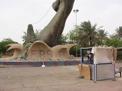 Base of one of the Hands of Victory with caretakers booth and Iraqi policemen 2004