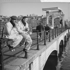 Two workers enjoying the first summer day in February sun on the Magere Brug bridge in Amsterdam in 1965
