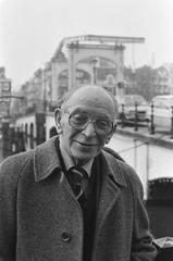 Black and white photo of Amsterdam cabaret artist and director Sylvain Poons with a narrow bridge in background
