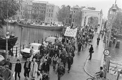 Demonstrators walking over Magere Brug during protest against demolition in Amsterdam