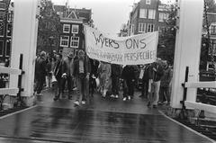 Protesters with banner marching over Magere Brug in Amsterdam during 1983 demonstration against demolition of Wyers squatter complex
