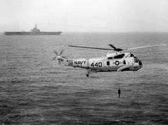 U.S. Navy Sikorsky SH-3D Sea King helicopter lowering AN/AQS-13 dipping sonar near USS Intrepid aircraft carrier in 1972