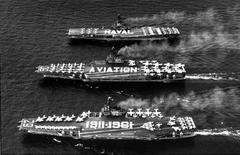 U.S. Navy aircraft carriers USS Independence, USS Saratoga, and USS Intrepid underway in 1961 with crewmen on deck forming a commemorative spellout for 50th birthday of U.S. naval aviation