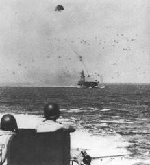 Japanese kamikaze plane preparing to strike aircraft carrier Intrepid with Battleship New Jersey anti-aircraft gun crew watching
