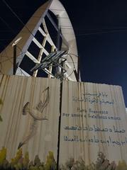 Wall piece at Sayedat al-Nejat featuring a dove and multilingual inscription honoring Father Francis for love and human brotherhood