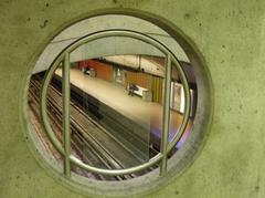 Man reading a newspaper on a bench in a Montreal metro station