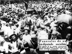 Funeral ceremony with people mourning and gathered around a casket outdoors