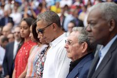 U.S. President Barack Obama, First Lady Michelle Obama, daughters Sasha and Malia, and Cuban President Raul Castro bowing for a moment of silence at Estadio Latinoamericano in Havana