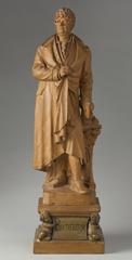 Terracotta gilded statue of Willem Bilderdijk, standing with a book and mantle, detailed with jabot and cravatte, on a profiled pedestal with a cartouche supported by putti