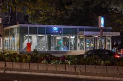 Entrance to Atwater metro station viewed from across Atwater Avenue at night with illuminated signage and streetlights