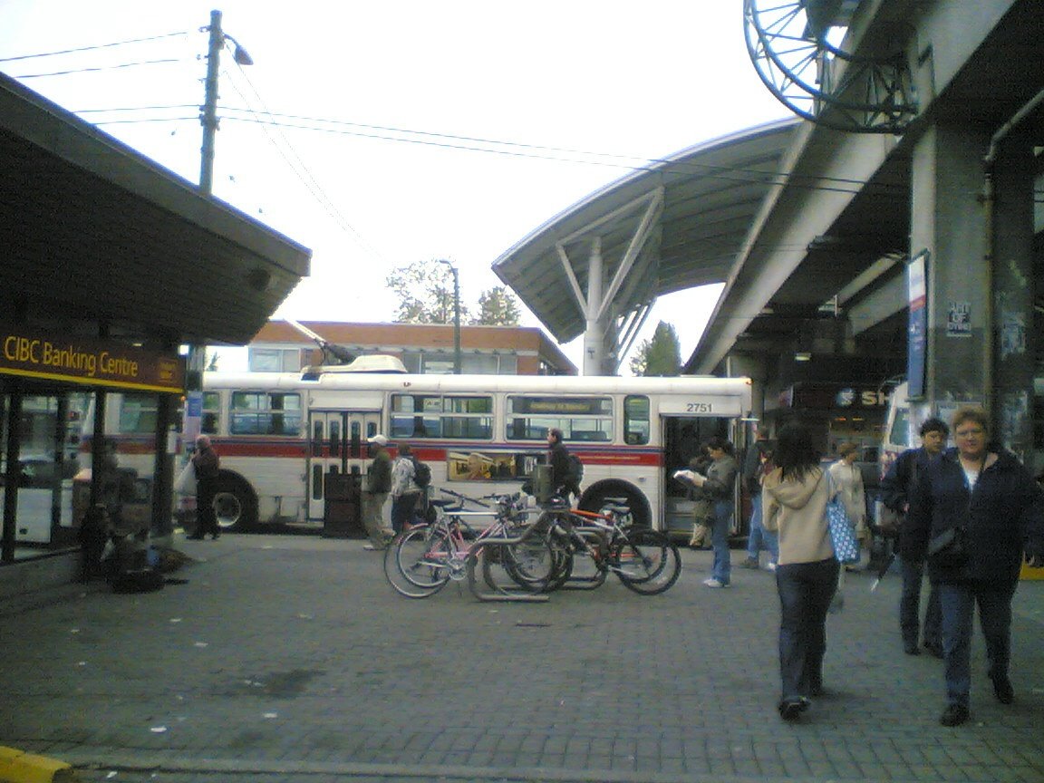Early morning commuter bustle at Broadway Station with people waiting on platform and train arriving