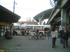 Early morning commuter bustle at Broadway Station with people waiting on platform and train arriving