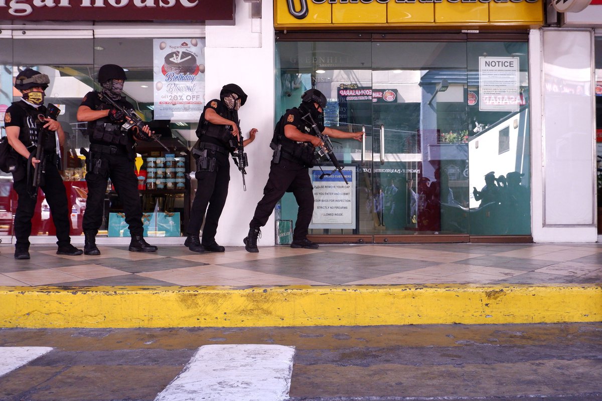 PNP SWAT team members taking positions at mall entrance during Greenhills hostage crisis