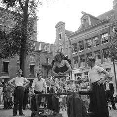 Black and white photo of an acrobat performing at Leidseplein during Amsterdam Liberation Day celebrations on June 28, 1945
