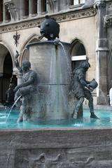 Two butchers emptying their water buckets into the Fischbrunnen fountain at Marienplatz, Munich
