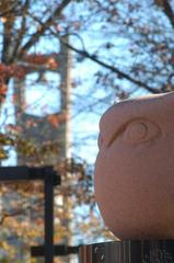 Owl statue perched on the Alumni Circle with the Bell Tower in the background