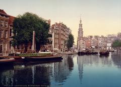 The Singel canal in Amsterdam with historical buildings and boats near the Munttoren tower at Muntplein