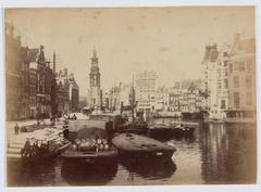 Historic photo of the Amstel river at Muntplein Amsterdam circa 1889-1894 showing the demolished corner building of Kalverstraat, Hotel Rondeel, Nieuwe Doelenstraat, and Doelensluis bridge 220 with Munttoren tower in the background